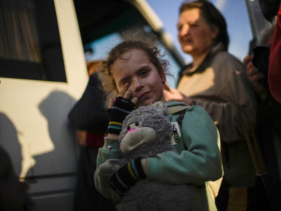 Un bambino e la sua famiglia fuggiti da Mariupol arrivano in un centro di accoglienza per sfollati a Zaporizhzhia. (AP Photo/Francisco Seco)