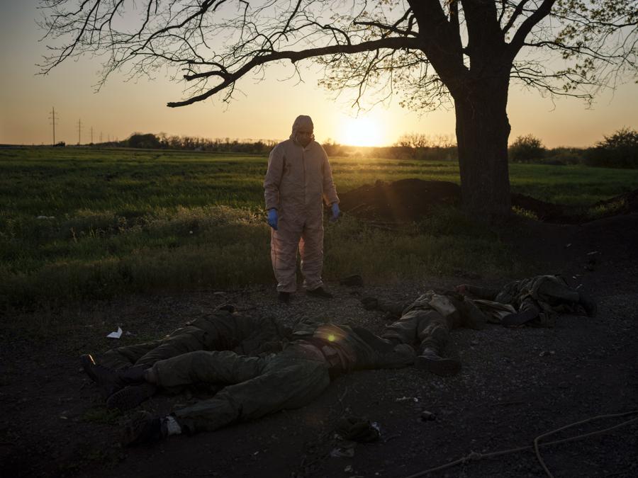 Un soccorritore ucraino si trova accanto ai corpi dei soldati russi nel villaggio di Vilkhivka, recentemente ripreso dalle forze ucraine vicino a Kharkiv, in Ucraina. (AP Photo/Felipe Dana)