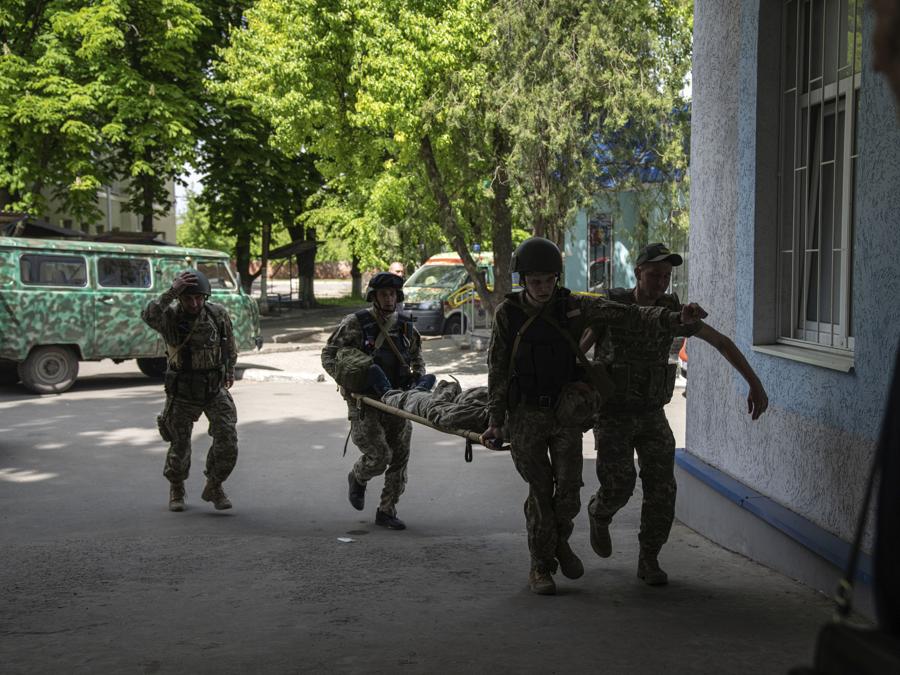 I militari ucraini trasportano un compagno ferito sulla barella  in un ospedale dopo un attacco delle forze russe nella regione di Donetsk, in Ucraina.(AP Photo/Evgeniy Maloletka)