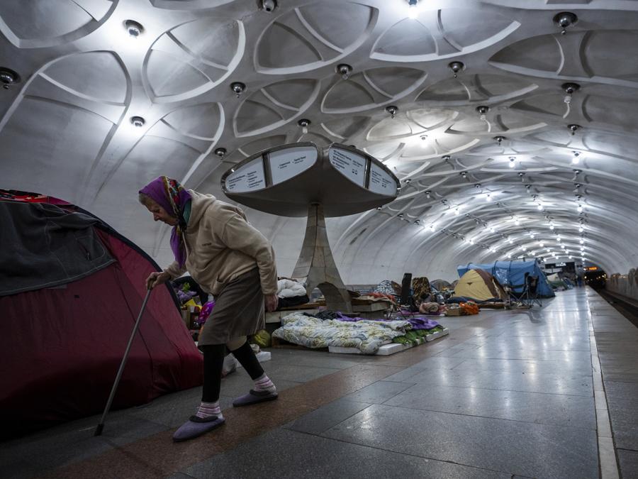 Una donna anziana cammina all’interno di una stazione della metropolitana utilizzata come rifugio antiaereo a Kharkiv. (AP Photo/Mstyslav Chernov)