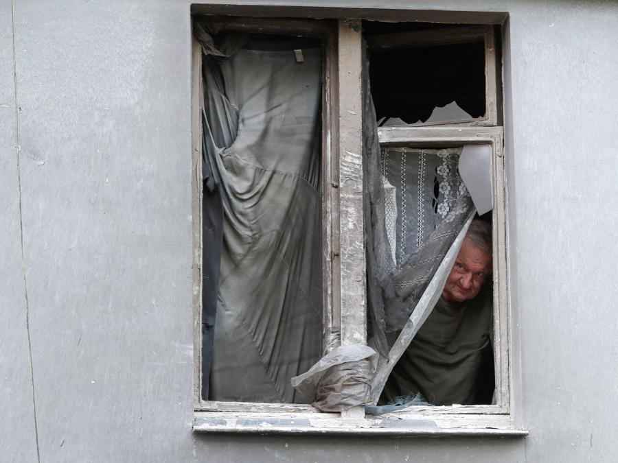 Il residente locale Vladimir Lebed guarda fuori da un appartamento in un edificio danneggiato durante il conflitto Ucraina-Russia nella città portuale meridionale di Mariupol. REUTERS/Alexander Ermochenko