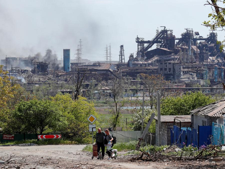 Alcune persone trasportano i loro effetti personali lasciando alle loro spalle l’acciaieria  Azovstal, Mariupol. REUTERS/Alexander Ermochenko