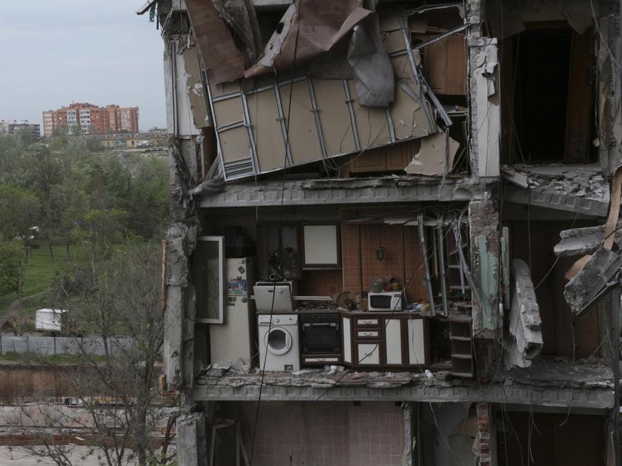 Una parte di un appartamento è vista accanto a edifici danneggiati durante un pesante combattimento a Mariupol, nel territorio sotto il governo della Repubblica popolare di Donetsk, nell’Ucraina orientale. (AP Photo)