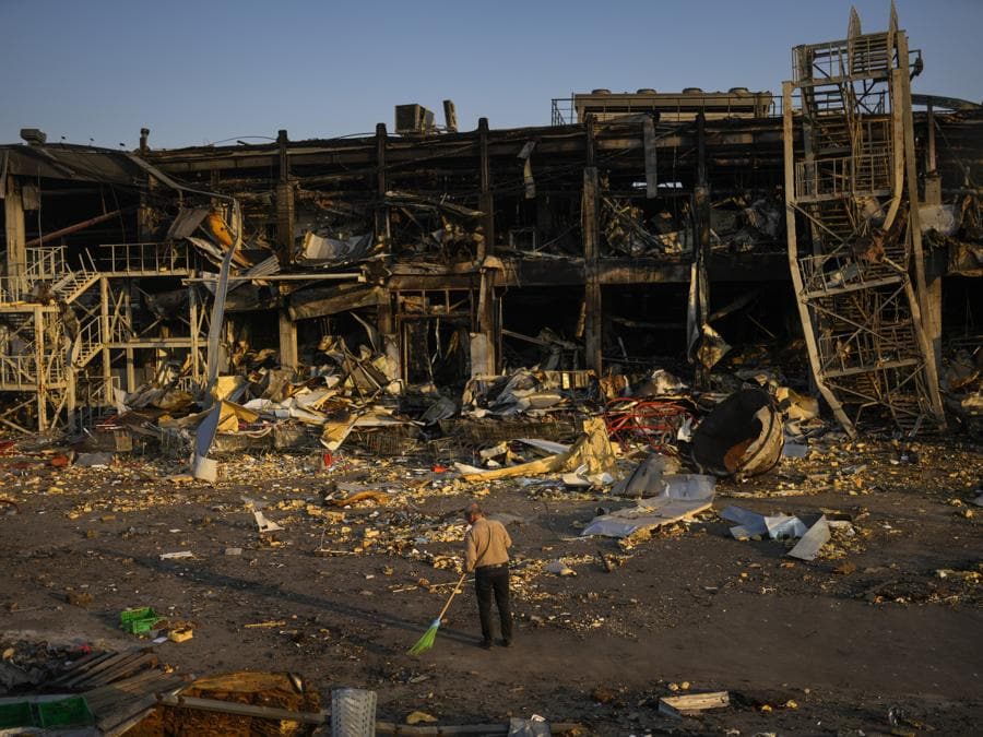 Un uomo spazza le macerie accanto a un centro commerciale e di intrattenimento distrutto dopo un attacco missilistico russo il 9 maggio a Odessa, in Ucraina. (AP Photo/Francisco Seco)