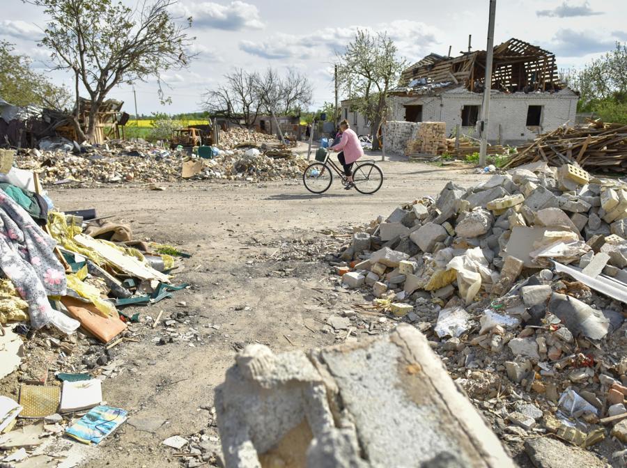 Una donna va in bicicletta vicino a case danneggiate nel villaggio di Zahaltsi vicino a Kiev. Il 24 febbraio le truppe russe sono entrate in territorio ucraino dando inizio a un conflitto che ha provocato distruzione e una crisi umanitaria. Secondo i dati diffusi dall’agenzia delle Nazioni Unite per i rifugiati UNHCR l’11 maggio, oltre sei milioni di ucraini sono fuggiti dal loro paese dal 24 febbraio 2022. (EPA/OLEG PETRASYUK)