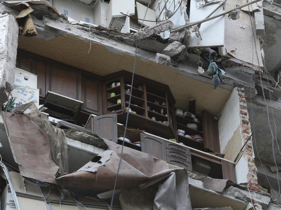 Una parte di un appartamento è vista a fianco di edifici danneggiati durante un pesante combattimento a Mariupol, nel territorio sotto il governo della Repubblica popolare di Donetsk, Ucraina orientale. (AP Photo)