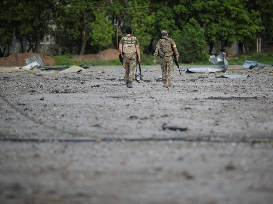 I militari ucraini camminano tra le macerie in un’area danneggiata, mentre continua l’attacco della Russia all’Ucraina, a Kharkiv. (REUTERS/Ricardo Moraes)