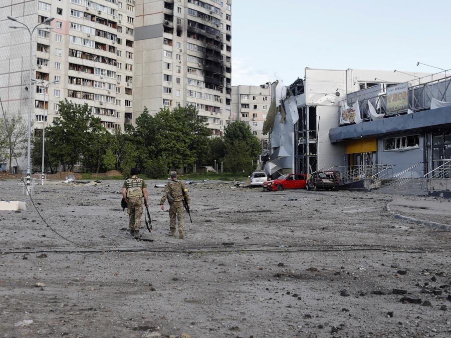 I militari ucraini camminano in un’area danneggiata, mentre continua l’attacco della Russia all’Ucraina, a Kharkiv. (REUTERS/Ricardo Moraes)