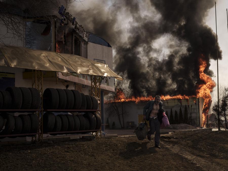 Un uomo recupera oggetti da un negozio in fiamme a seguito di un attacco russo a Kharkiv. (AP Photo/Felipe Dana)