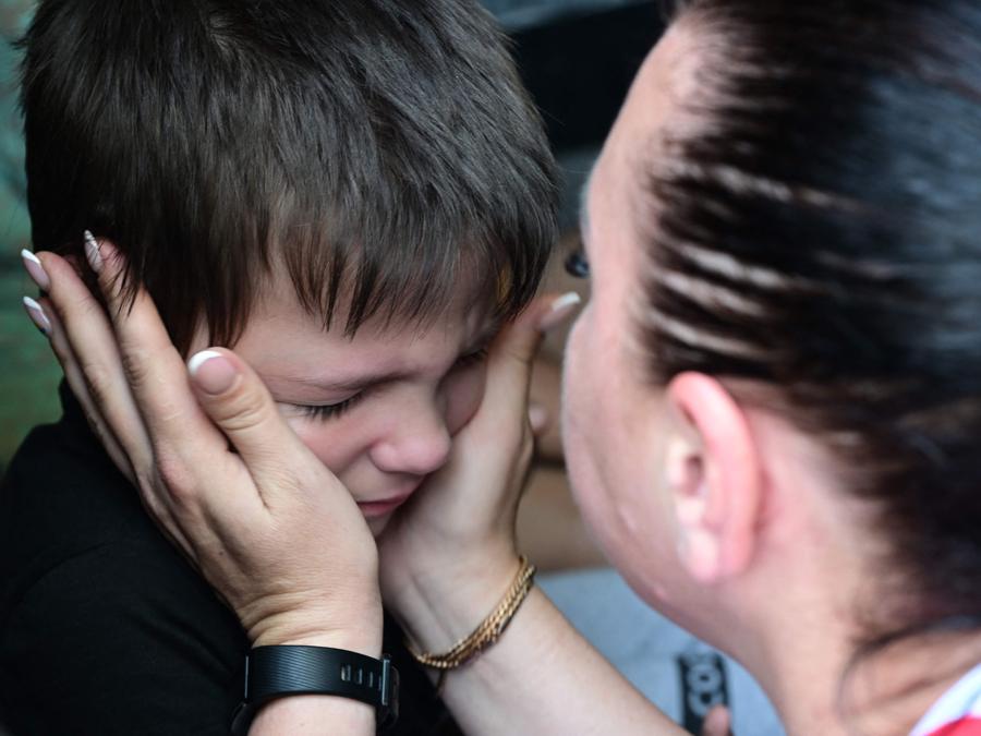 Una donna saluta suo figlio prima della sua evacuazione dalla città di Sloviansk alla città di Dnipro. (Photo by MIGUEL MEDINA / AFP)