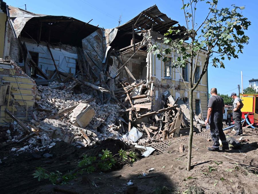 I soccorritori lavorano tra le rovine di un edificio amministrativo distrutto dai missili russi a Kharkiv. (Photo by SERGEY BOBOK / AFP)