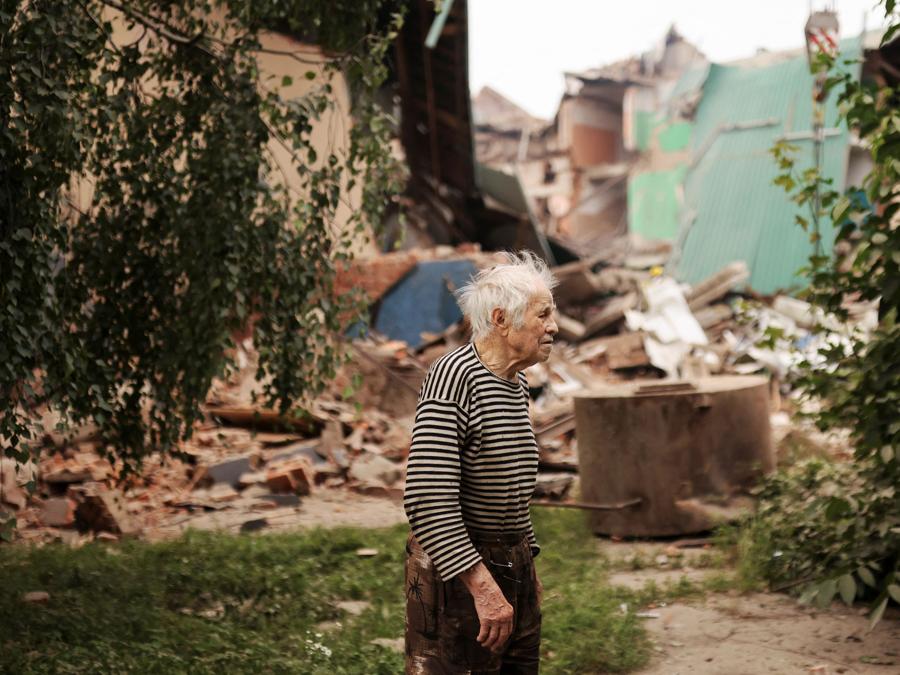 Vladimir, 93 anni, passa davanti alla Casa Centrale della Cultura dopo che un attacco militare ha colpito un edificio, mentre l’invasione russa dell’Ucraina continua, a Chuhuiv, nella regione di Kharkiv. REUTERS/Nacho Doce