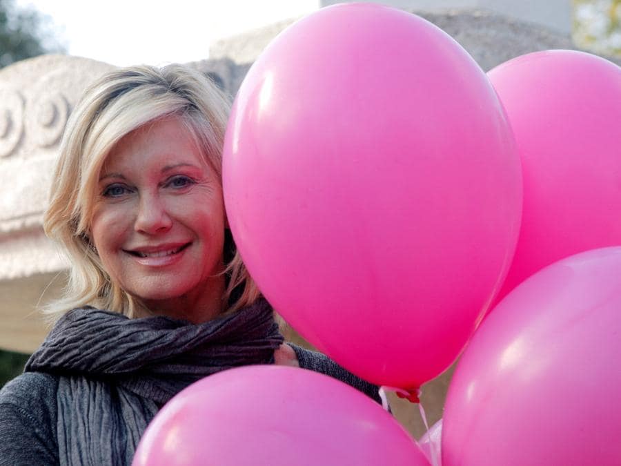 2009 - La cantante e attrice australiana Olivia Newton-John posa per promuovere la campagna contro il cancro al seno “Pink Ribbon” a Vienna. (REUTERS/Heinz-Peter Bader/File Photo)