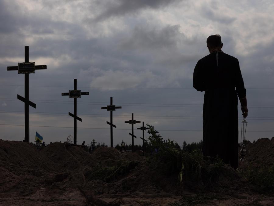 Il sacerdote ortodosso Andrii Halavin benedice i resti di persone non identificate che sono state uccise nel distretto di Bucha al momento dell’occupazione russa, durante la sepoltura di massa in un cimitero di Bucha, a nord-ovest di Kiev, Ucraina. EPA/ROMAN PILIPEY