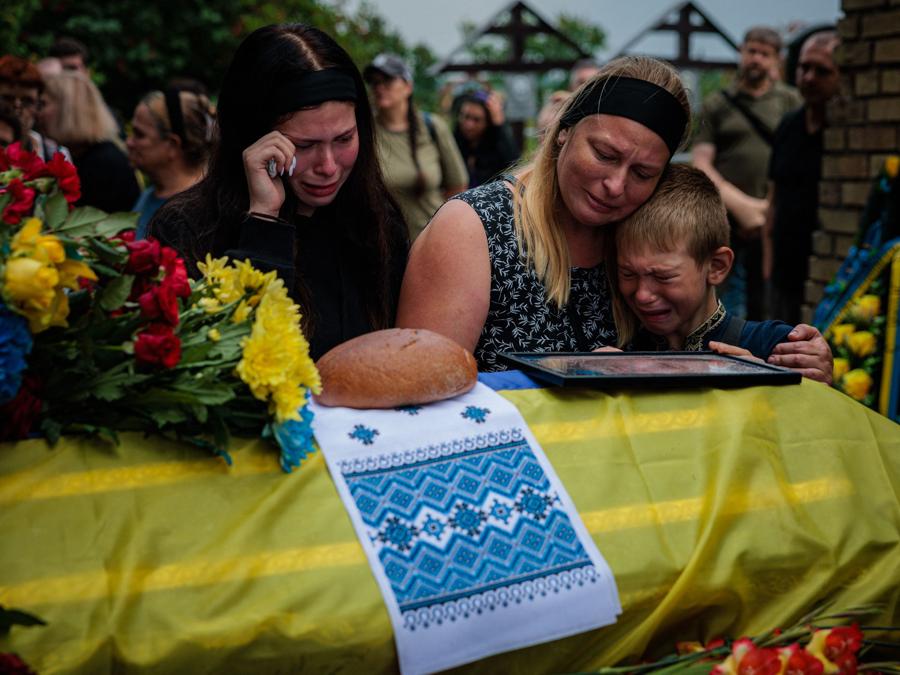 I Familiari piangono accanto alla bara del militare ucraino Anton Savytskyi durante una cerimonia funebre al cimitero di Bucha nella regione di Kiev. (Photo by Dimitar DILKOFF / AFP)