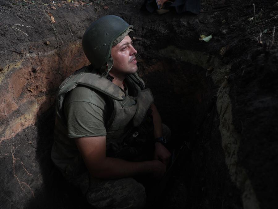 Un soldato ucraino siede in una trincea in una posizione lungo la linea del fronte nella regione di Donetsk. (Photo by Anatolii Stepanov / AFP)