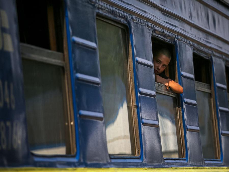 Un ragazzo guarda fuori dal finestrino su un treno di evacuazione dalla regione del Donbas a ovest dell’Ucraina, nella stazione ferroviaria di Udachnoye. (Photo by ANATOLII STEPANOV / AFP)