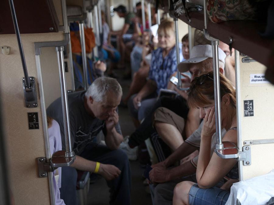 Le persone salgono a bordo di un treno di evacuazione dalla regione del Donbas a ovest dell’Ucraina, nella stazione ferroviaria di Udachnoye. (Photo by ANATOLII STEPANOV / AFP)