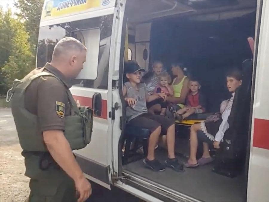 Gli agenti di polizia evacuano i residenti, nel mezzo dell’invasione russa dell’Ucraina, a Maryinka, regione di Donetsk. State Donetsk Region Police/Handout via REUTERS 