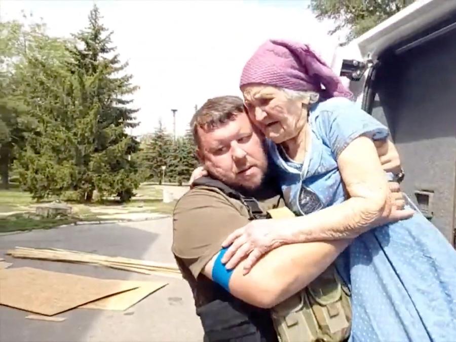Gli agenti di polizia evacuano i residenti, nel mezzo dell’invasione russa dell’Ucraina, a Maryinka, regione di Donetsk. State Donetsk Region Police/Handout via REUTERS