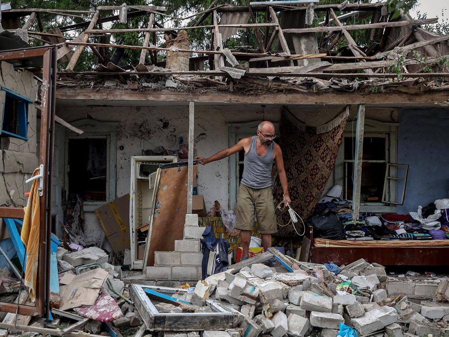 Un residente locale raccoglie oggetti dalla sua casa distrutta dopo un attacco missilistico notturno nella città di Kramatorsk, nella regione di Donetsk. (Photo by ANATOLII STEPANOV / AFP)
