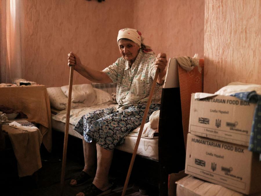 Levdokiia Levkivna, 84 anni, siede sul suo letto accanto a scatole di cibo umanitario nella sua casa a Siversk, a circa 6 km dalla prima linea, mentre l’invasione russa dell’Ucraina continua, nella regione di Donetsk . REUTERS/Nacho Doce