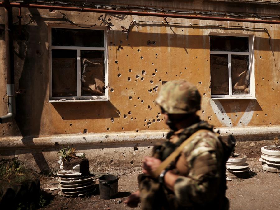 Un militare ucraino oltrepassa i segni di schegge su un edificio distrutto, a circa 6 km dalla prima linea, mentre l’invasione russa dell’Ucraina continua, a Siversk, nella regione di Donets. REUTERS/Nacho Doce TPX IMAGES OF THE DAY