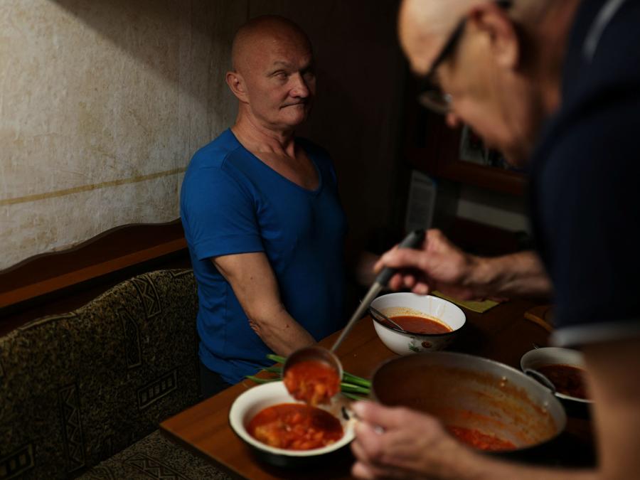 Vladimir Bezruk, 65 anni, serve cibo a Victor Solovyanenko, 54 anni, ipovedente, in un ostello per non vedenti, durante l’invasione russa dell’Ucraina, a Kharkiv. REUTERS/Nacho Doce