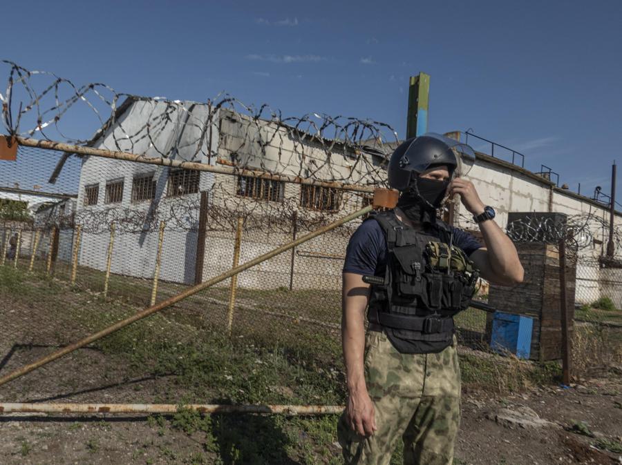 Una foto scattata durante una visita a Yelenovka organizzata dall’esercito russo mostra un’autoproclamata guardia della milizia della DPR fuori dalla caserma dove erano detenuti i prigionieri di guerra ucraini in un centro di detenzione di Yelenovka a Yelenovka, regione di Donetsk, Ucraina. (Epa/Sergei Ilnitsky)
