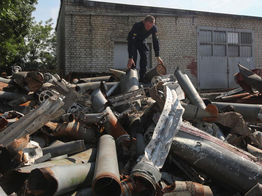 Un geniere del servizio di emergenza statale ucraino osserva e valuta diversi missili e razzi russi raccolti dai suoi colleghi a Kharkiv. (Reuters/Vyacheslav Madiyevskyy)