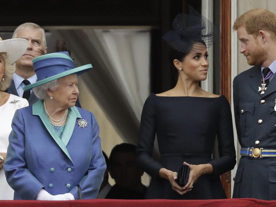 In questa foto del  10 luglio 2018, la regina Elisabetta II, Meghan, la duchessa di Sussex e il principe Harry, stanno su un balcone per guardare il passaggio di un aereo della Royal Air Force su Buckingham Palace a Londra. (AP Photo/Matt Dunham, File)