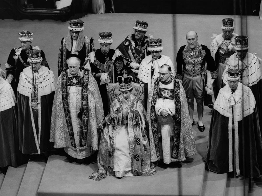 La regina Elisabetta II  siede su un trono durante la sua incoronazione nell’Abbazia di Westminster a Londra. (Photo by CENTRAL PRESS PHOTO LTD / AFP)