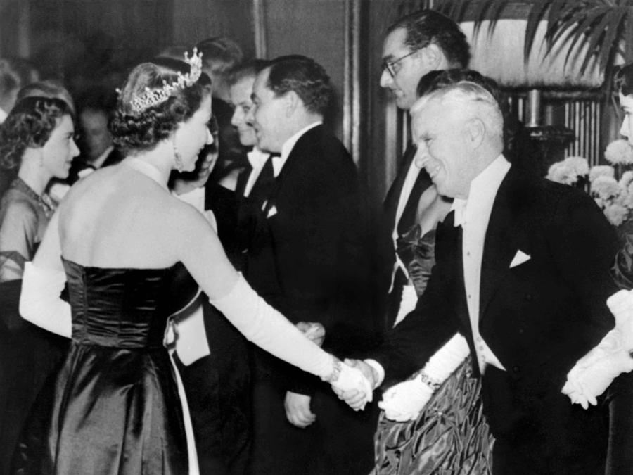 L’attore britannico Charlie Chaplin stringe la mano alla regina Elisabetta II  il 27 ottobre 1952.. (Photo by AFP)