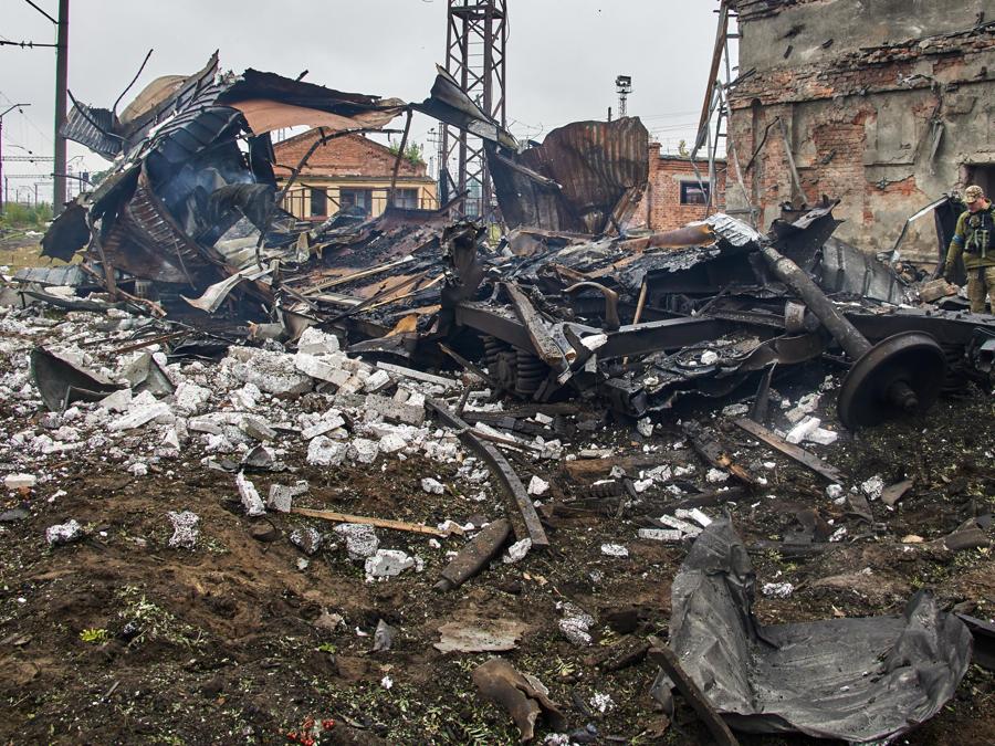 Un militare ucraino si trova accanto a un vagone merci distrutto bloccato nei bombardamenti russi, a Kharkiv. (EPA/Sergey Kozlov)