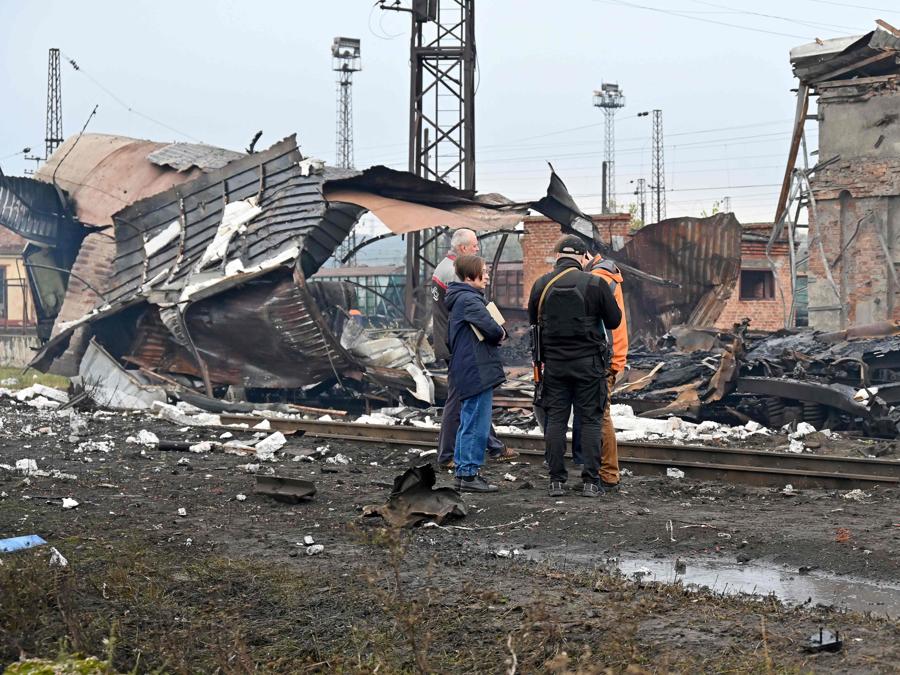 Esperti di polizia e operatori ferroviari esaminano la posizione di un attacco missilistico in una stazione ferroviaria merci a Kharkiv. (Photo by Sergey Bobok / AFP)