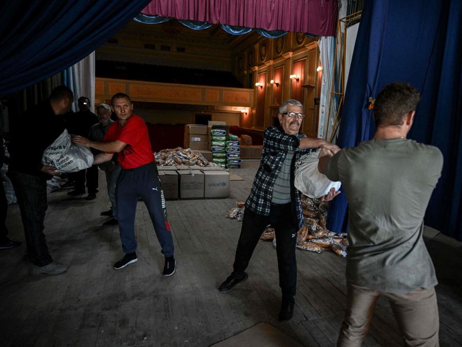 I volontari scaricano un carico di cibo presso un centro di assistenza a Chasiv Yar, nell’Ucraina orientale. (Photo by Juan Barreto / AFP)
