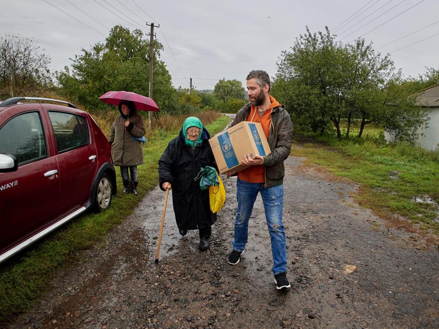 Un volontario porta aiuti umanitari ai residenti del villaggio di Arkadivka, nella regione di Kharkiv. (EPA/Sergey Kozlov)