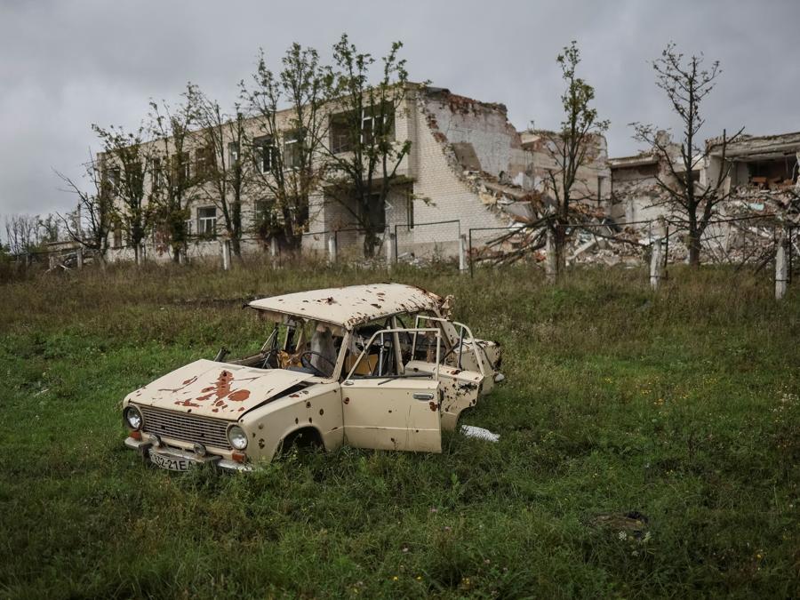 Un’auto  davanti a una scuola distrutta,  nel villaggio di Dolyna. (REUTERS/Gleb Garanich)