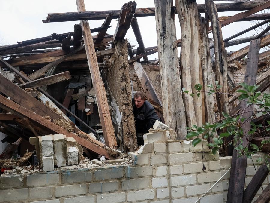 Lo stesso uomo controlla la sua casa distrutta,nel villaggio di Dolyna. (REUTERS/Gleb Garanich)