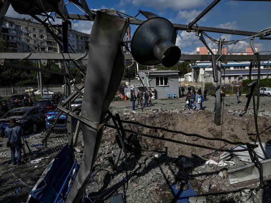 Alcune persone osservano un cratere lasciato da un attacco missilistico russo a Zaporizhzhia. (REUTERS/Stringer)