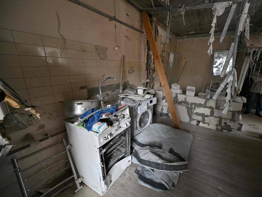 Un uomo si trova in un appartamento parzialmente distrutto in un condominio a Irpin, nella regione di Kiev. Ora l’avanzare dell’inverno presenta una minaccia diversa con le riparazioni edilizie urgenti necessarie per respingere il freddo e la pioggia. (Photo by Sergei Supinsky / AFP)