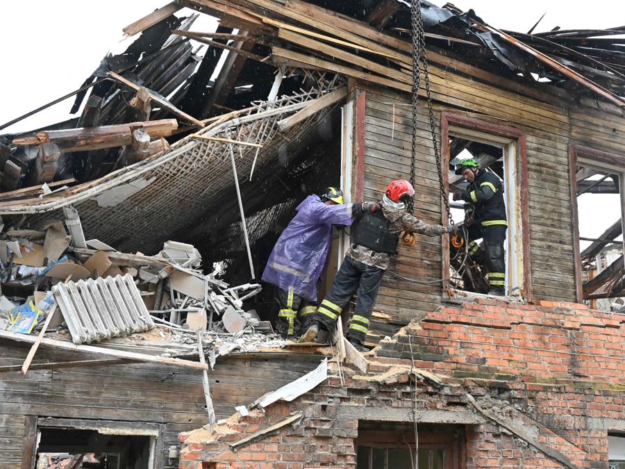I soccorritori ucraini smantellano un liceo distrutto a Izyum, nella regione di Kharkiv. (Photo by Sergey Bobok / AFP)