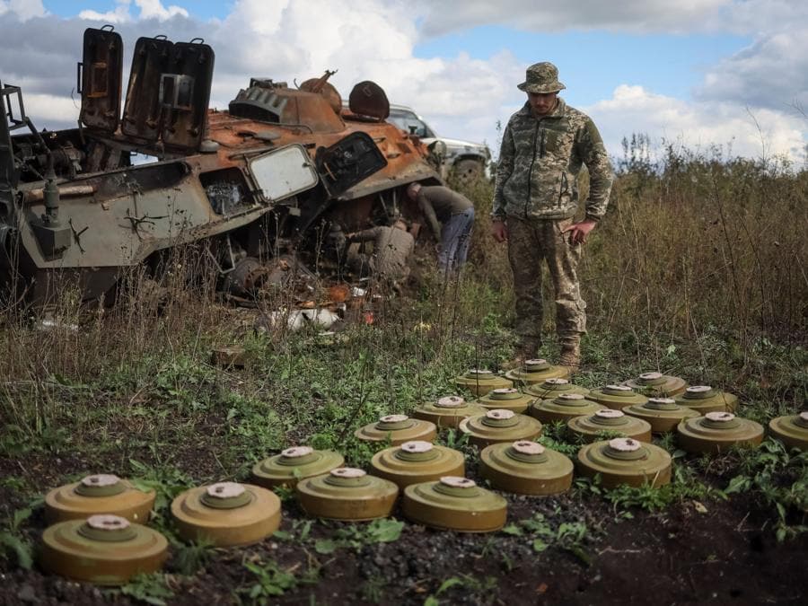 Un militare ucraino esamina le mine anticarro vicino a una  corazzata russa distrutta, vicino alla città di Izium, nella regione di Kharkiv. (REUTERS/Gleb Garanich)