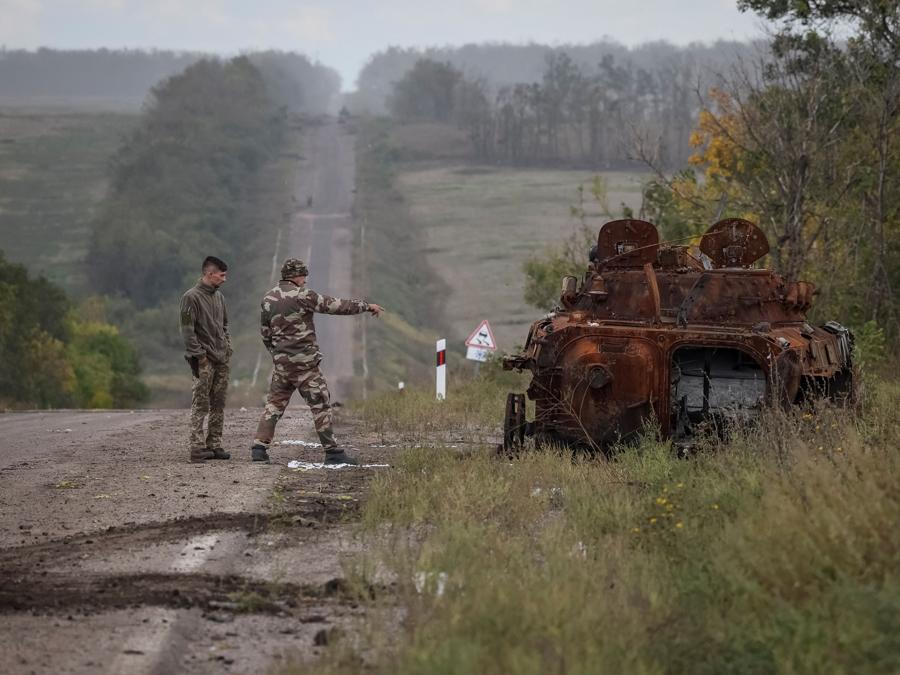 Militari ucraini esaminano una  corazzata russa distrutta, nelle campagne vicino alla città di Izium, nella regione di Kharkiv. (REUTERS/Gleb Garanich)