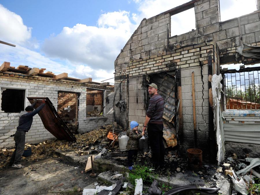I residenti ripuliscono le macerie della loro casa distrutta a seguito dei bombardamenti nel villaggio di Moshchun, nella regione di Kiev. (Photo by Sergei Chuzavkov / AFP)