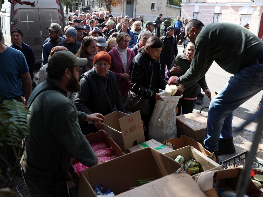 Un uomo distribuisce aiuti alimentari ai residenti di Izyum, nella regione nord-orientale di Kharkiv. (Photo by Anatolii Stepanov / AFP)