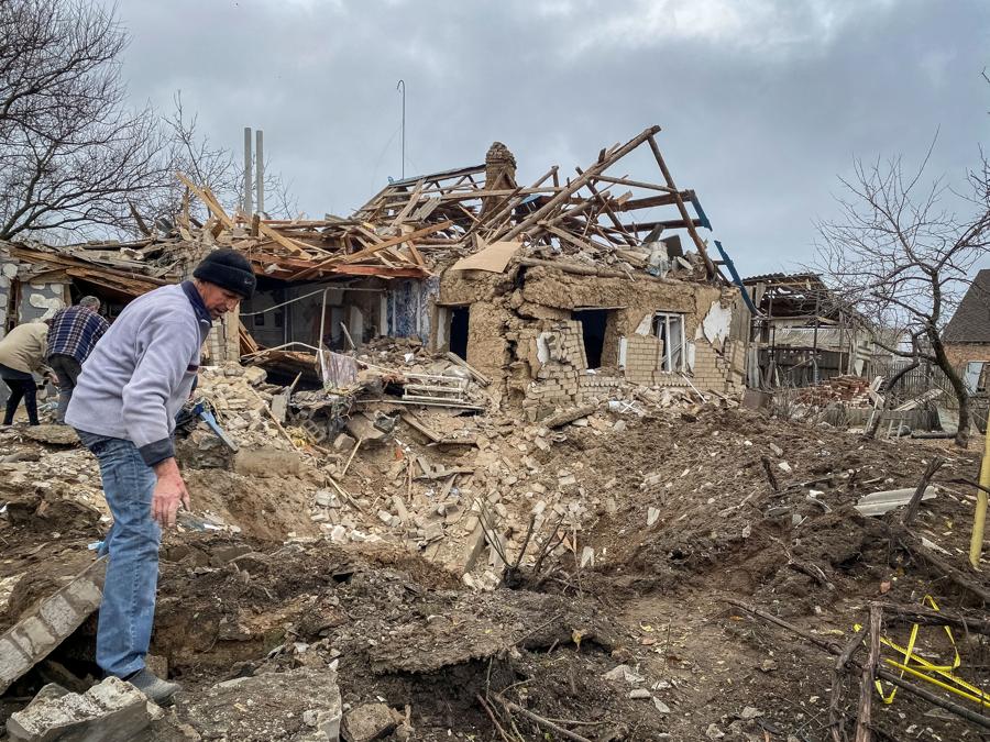 I residenti locali ispezionano un cratere lasciato da un attacco militare russo, mentre il loro attacco in Ucraina continua, nel villaggio di Komyshuvakha, regione di Zaporizhzhia, Ucraina. REUTERS/Sergiy Chalyi