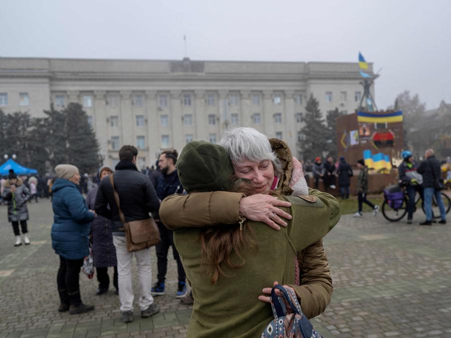 Una donna abbraccia la sua amica che è un soldato dell’esercito ucraino a Kherson. (Photo by BULENT KILIC / AFP)