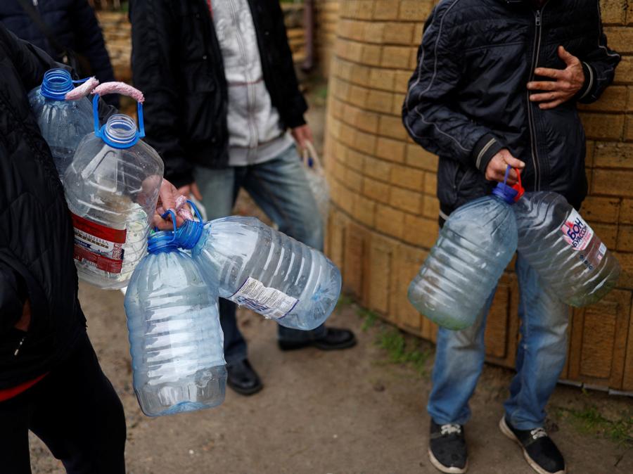 La gente aspetta di riempire le bottiglie d’acqua vicino al fiume Dnipro. REUTERS/Murad Sezer
