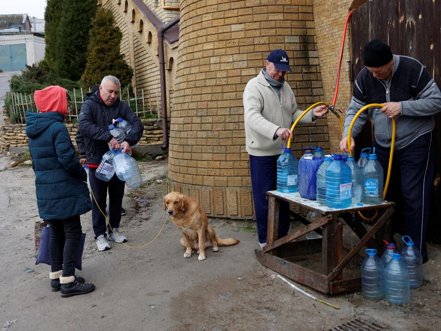 La gente riempie bottiglie d’acqua vicino al fiume Dnipro dopo la ritirata militare della Russia da Kherson. REUTERS/Murad Sezer